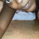 A black girl records herself taking a shit into a plastic grocery bag on the floor. Over 1.5 minutes.